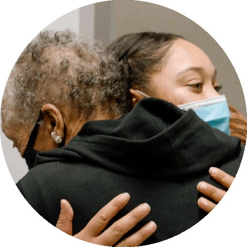 Nurse and elderly woman embracing